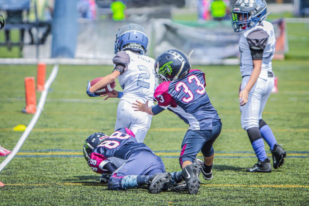 Youth football players colliding during a play