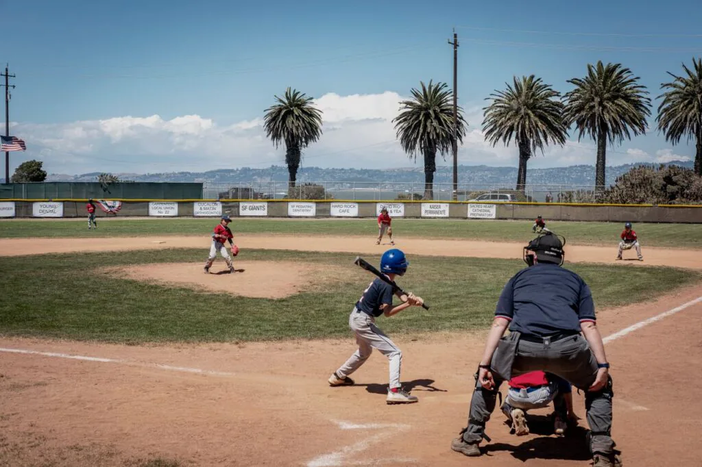 Youth baseball batter at the plate with the catcher behind him