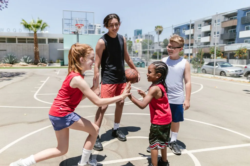 Kids playing basketball on an outdoor court